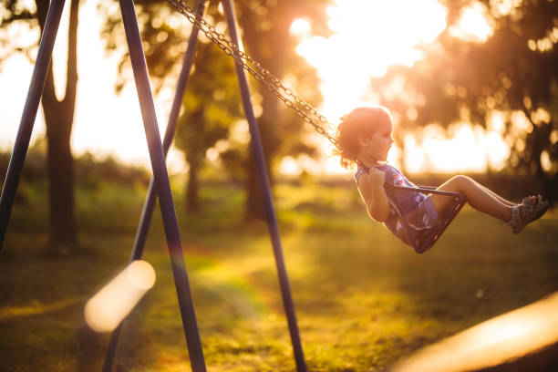 istock Little girl swinging at sunset 1174111100