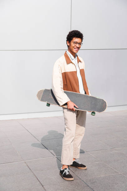 istock African american skater holds skateboard in hands 1174119002