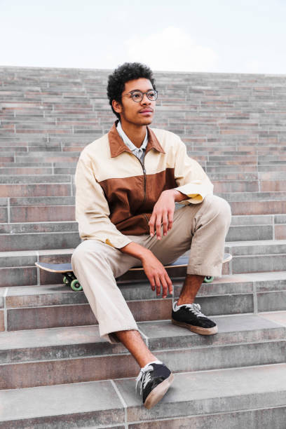 istock African skateboarder sitting and resting on stairs 1174119086