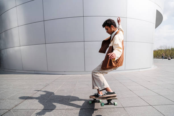 istock Afro skateboarder does ollie in front of building 1174119092