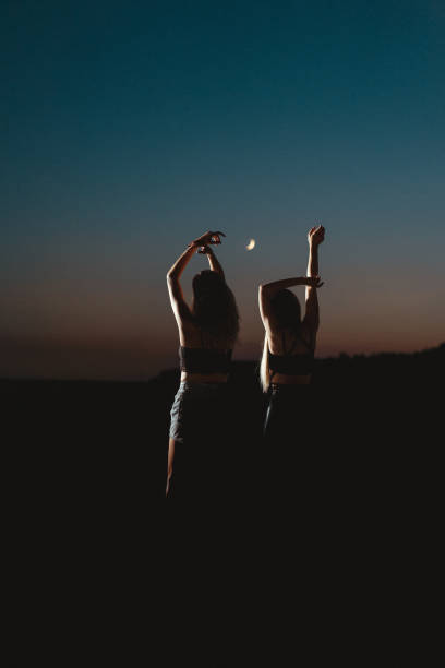istock Silhouette Women With Arms Raised Against Sky During Dusk 1174121960