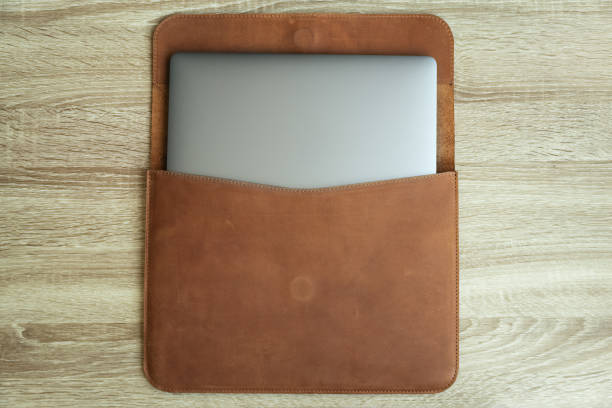 istock Brown leather case with laptop on wooden table. Top view. Copy space 1174124752