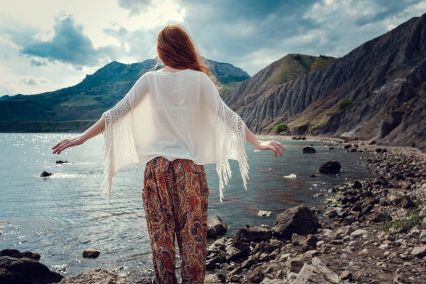 istock Beautiful boho styled model wearing white crochet swimsuit posing on the beach in sunlight 1174125401