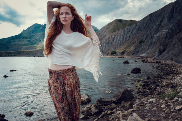 istock Beautiful boho styled model wearing white crochet swimsuit posing on the beach in sunlight 1174125867