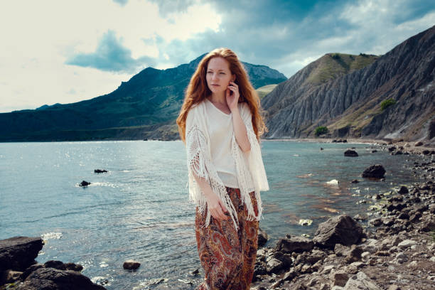 istock Beautiful boho styled model wearing white crochet swimsuit posing on the beach in sunlight 1174125984