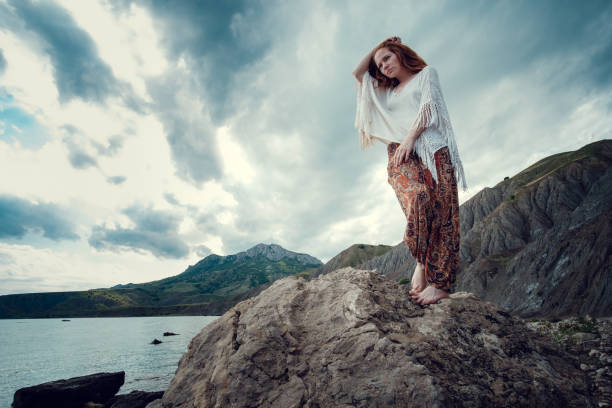 istock Beautiful boho styled model wearing white crochet swimsuit posing on the beach in sunlight 1174126151