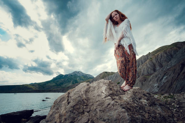 istock Beautiful boho styled model wearing white crochet swimsuit posing on the beach in sunlight 1174126864