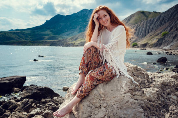 istock Beautiful boho styled model wearing white crochet swimsuit posing on the beach in sunlight 1174126870