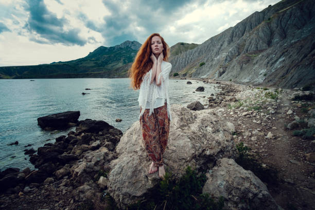 istock Beautiful boho styled model wearing white crochet swimsuit posing on the beach in sunlight 1174127091