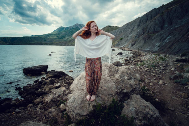 istock Beautiful boho styled model wearing white crochet swimsuit posing on the beach in sunlight 1174127093