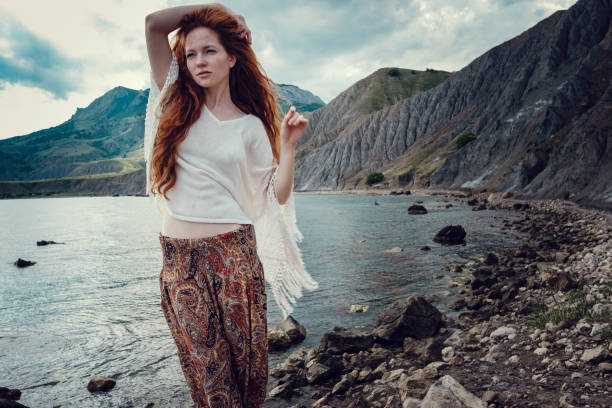 istock Beautiful boho styled model wearing white crochet swimsuit posing on the beach in sunlight 1174127273