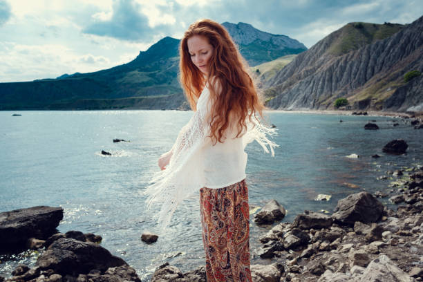 istock Beautiful boho styled model wearing white crochet swimsuit posing on the beach in sunlight 1174127307