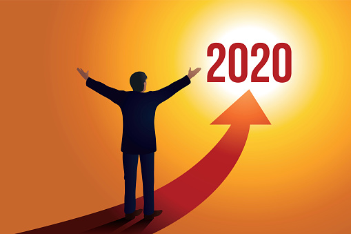 Greeting card 2020 showing a businessman opening his arms in front of a red arrow towards a sunny horizon, symbol of hope and success for the new year.
