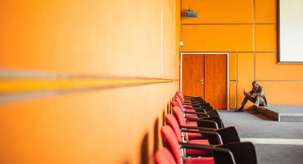 istock Businessman Sitting in a Empty Conference Room, Using Phone 1174129169