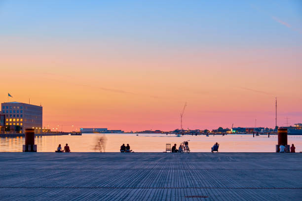People on the beach enjoy the sunset in the center of Copenhagen. stock photo