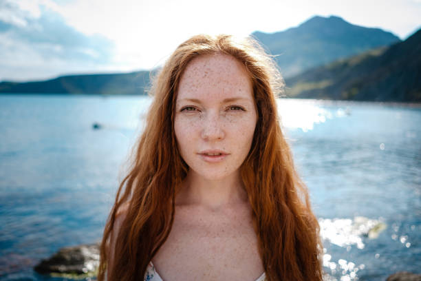 istock Beautiful boho styled model wearing white dress posing on the beach in sunlight 1174129717