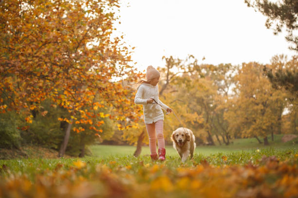 istock Little girl walking with dog 1174131128