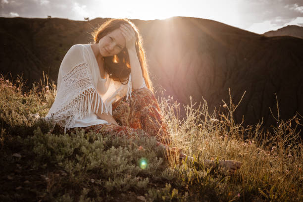 istock Red-haired cute woman resting in sunset mountains. 1174131331