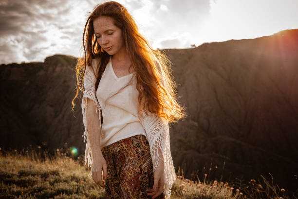 istock Red-haired cute woman resting in sunset mountains. 1174131641