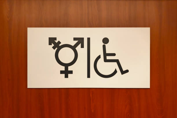 Washroom entrance with one advertisment sign on each side of door. Signs are being empty with black background, And there are the sign indicating washroom for woman, man, and handicap people with wheelchair