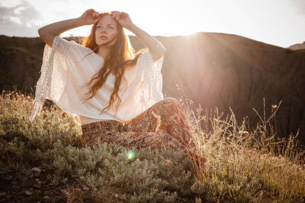istock Red-haired cute woman resting in sunset mountains. 1174131868