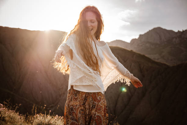 istock Red-haired cute woman resting in sunset mountains. 1174132220