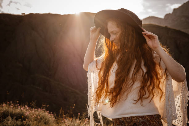 istock Red-haired cute woman resting in sunset mountains. 1174132352