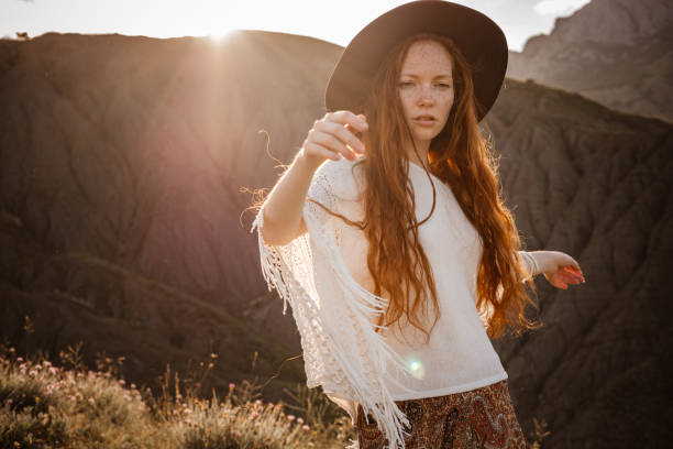 istock Red-haired cute woman resting in sunset mountains. 1174132415