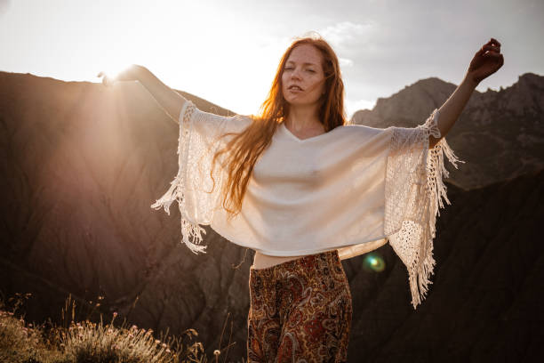 istock Red-haired cute woman resting in sunset mountains. 1174132417
