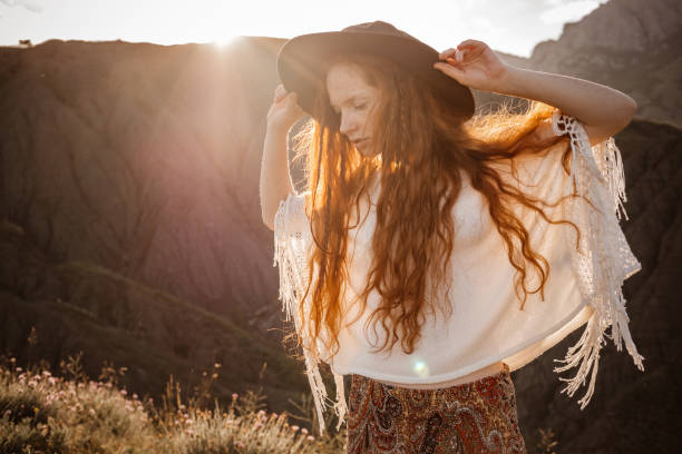 istock Red-haired cute woman resting in sunset mountains. 1174133154