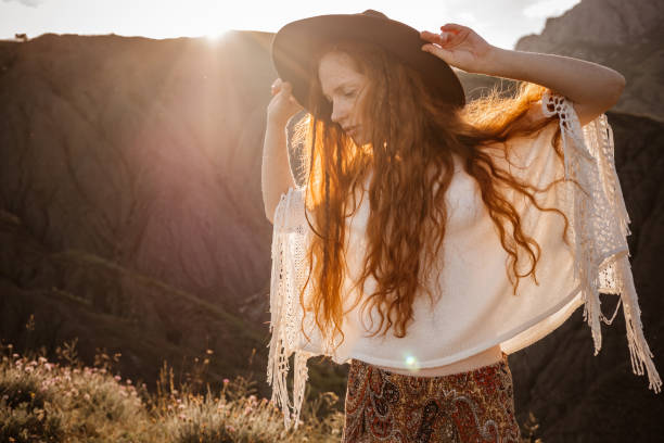 istock Red-haired cute woman resting in sunset mountains. 1174133156