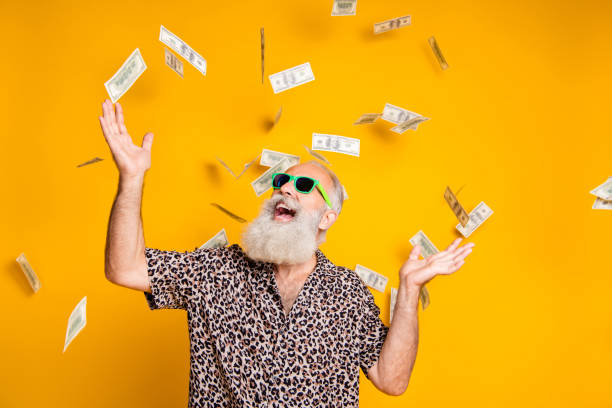 Portrait of crazy funky funny old bearded man hipster in green eyeglasses, eyewear look up at money falling scream great win lottery wear leopard stylish shirt isolated over yellow background Portrait of crazy funky funny old bearded man hipster in green eyeglasses, eyewear look up at money falling scream great win lottery wear leopard stylish shirt isolated over yellow background money rain stock pictures, royalty-free photos & images