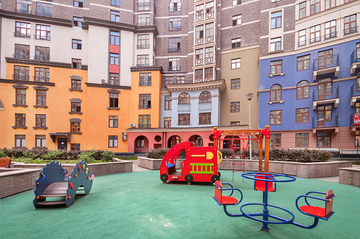 Colour children playground in new residential area complex at summer evening for sale. Urban development common area concept image