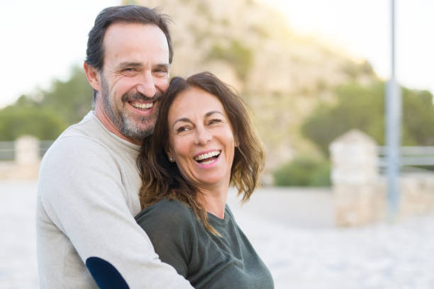 istock Romantic couple smiling,  cuddling and hugging on a sunny day 1174138480
