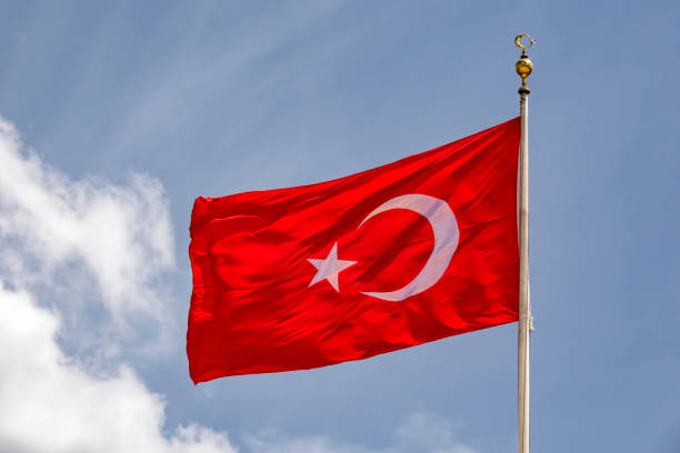 istock close up turkish flag at flagpole and blue sky with clouds. 1174138672