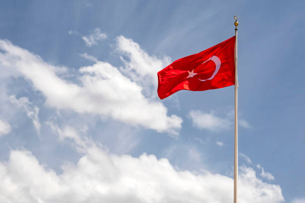 istock close up turkish flag at flagpole and blue sky with clouds. 1174138825