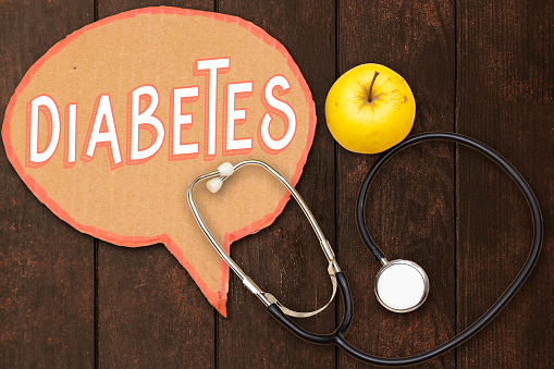 diabetes chat bubble, yellow apple with stethoscope on wood table,Concept for diet, healthcare, nutrition or medical insurance