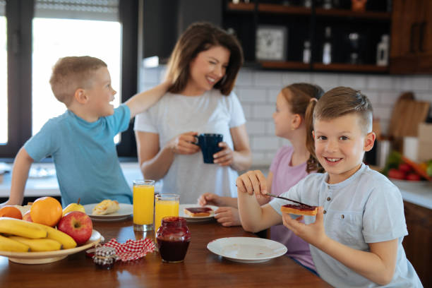 istock Mother and three kids in the kitchen eating breakfast 1174141640