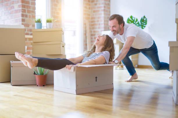 istock Middle age senior romantic couple having fun, riding inside of cardboard, excited and smiling happy for moving to a new home 1174145708