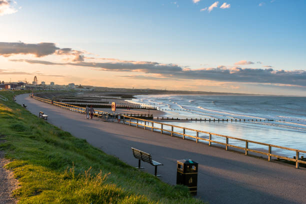 fußweg auf einem seeweichl entlang eines herrlichen sandstrandes bei sonnenuntergang - scenics pedestrian walkway footpath bench stock-fotos und bilder