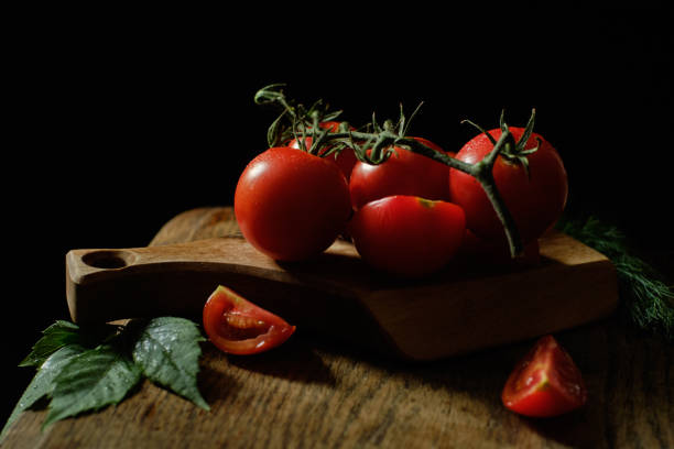 istock Red tomatoes lie on a wooden board 1174156172