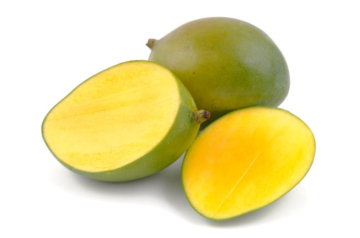 A mango and a halved mango isolated on white.