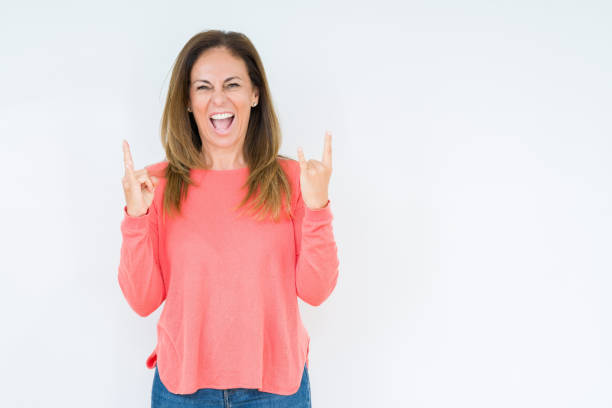 istock Beautiful middle age woman over isolated background shouting with crazy expression doing rock symbol with hands up. Music star. Heavy concept. 1174158307