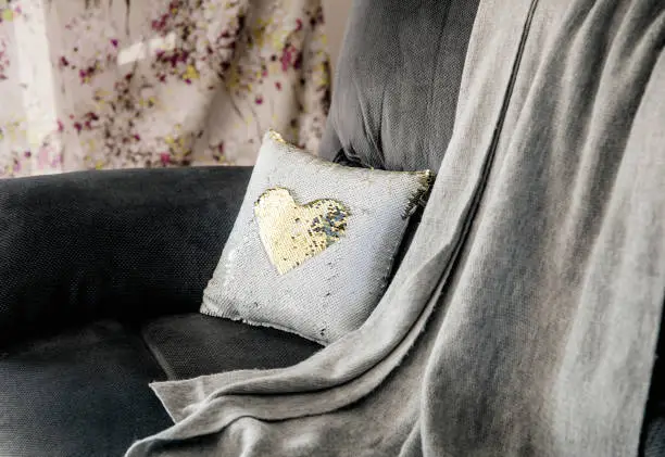Photo of Christmas decoration decorative pillow made of multi color gold and white shimmer sequin reversible fabric on home living room couch. Christmas decoration idea. New popular material.