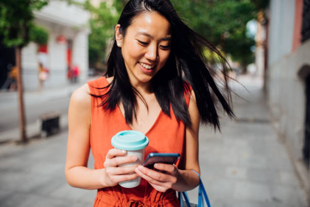 istock Asian woman holding phone and coffee 1174166991