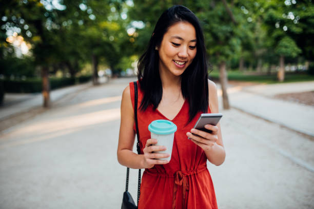 istock Asian girl walking with phone in hands 1174167036
