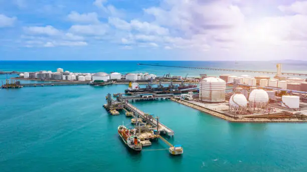 Photo of Aerial view white storage tank of oil and gas and petrochemical products ready for logistic and transport business.