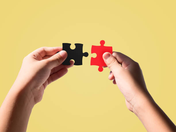 istock Hands holding black and red color jigsaws 1174172824