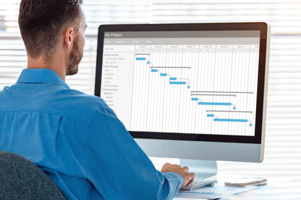 chef de projet dans les tâches de planification de bureau et la progression des étapes d'étape terminées avec la planification de diagramme de gantt sur l'ordinateur, le logiciel professionnel de gestion de temps - chef de projet photos et images de collection
