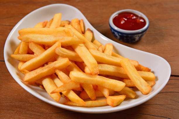 French Fries French Fries plate on wooden background fried potato stock pictures, royalty-free photos & images